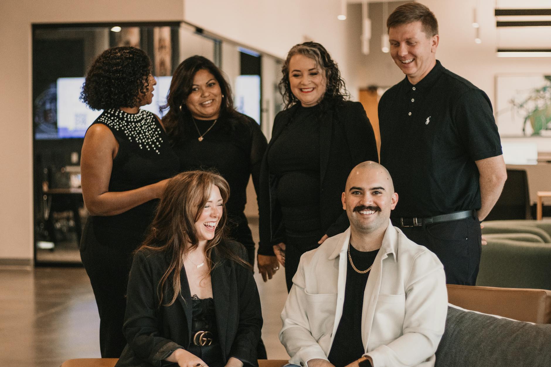 Diverse real estate team engaged in conversation in a modern office setting.